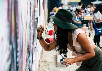 Um coletivo de mulheres, criando um mural de arte urbana.
