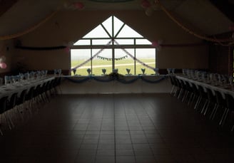 une salle de réception sombre avec des fenêtres au milieu