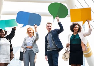 Colaboradores segurando balões de comunicação simbolizando comunicação eficiente empresarial