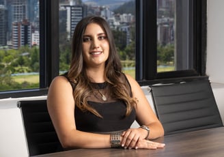 Retrato corporativo de joven mujer abogada con cabello rubio posando de forma profesional en una sala de reuniones