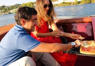 A couple enjoying wine and snacks on the James Bond–style speedboat Eskrok