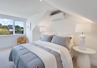 Bright attic bedroom interior with dormer windows, white color palette and minimalist design details