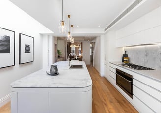 Modern kitchen interior design with central island, white cabinetry, integrated appliances