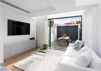 Modern living room with white sofa, custom TV cabinet, and ducted air conditioning system
