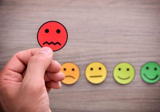Carinhas com níveis emocionais de triste a feliz simbolizando feedbacks empresariais