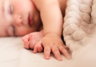 a baby is laying on a bed with a blanket