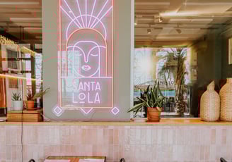 Interior del restaurante Santa Lola con neón rosa iluminado