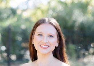 A white woman with brown hair smiling