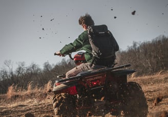 Tourist riding ATV through muddy jungle trails and rice fields in Bali on an off-road adventure tour