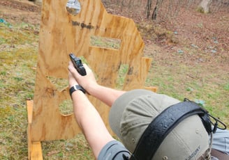 Man using Self-defense firearm from behind a barrier on training range.