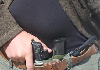 Man grips defensive firearm from concealment.
