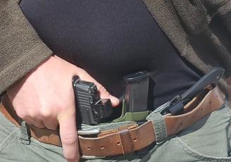 Man grips defensive firearm from concealment.