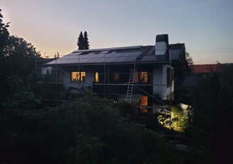 a house with a solar paneled roof and a ladder