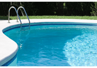 Medium shot of a kidney-shaped clear-blue pool with ladder