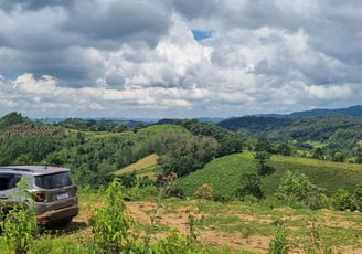 a car parked on a hill with a view of the mountains