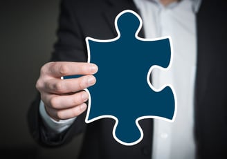 Hand with puzzle piece, symbolizing personalized solutions