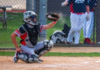 a catcher is holding a baseball glove