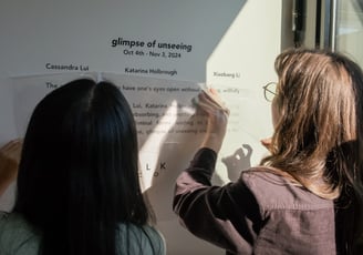 two women are standing in front of a sign