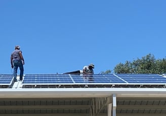 Two of our employees installing solar panels