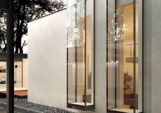 Fachada arquitectónica revestida en madera y vidrio, con cerramientos móviles para regular luz y privacidad