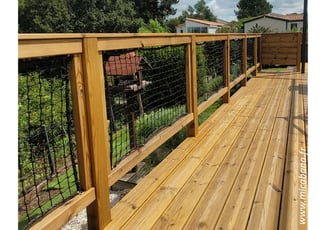 terrasse en bois sur pilotis avec rambardes cadres avec filets, poteaux et main courante en bois