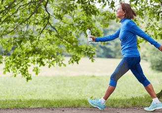 a woman in a blue shirt is running on a path