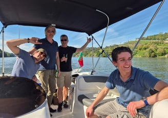 Smiling guests posing for a photo on the Endure speedboat on a quiet stretch of the Douro River