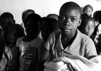 a group of children in a classroom with a blanket