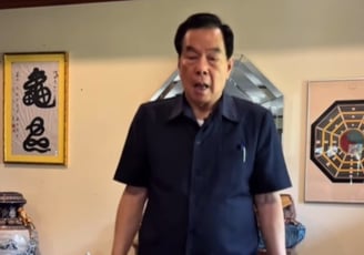 a man in a blue shirt is holding a cake