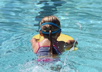 young child learning to swim