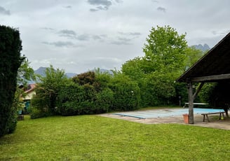 Entretien de jardin : pelouse tondue et haies taillées près d’une piscine