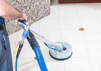 Professional tile and grout cleaning technician meticulously cleaning floor tiles. Noticeably clean.