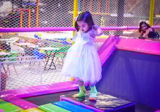 a little girl in a white dress and green socks