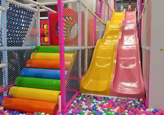 a colorful ball pit with a slider and a slider