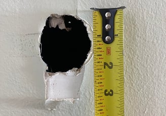 measuring a drywall hole for repair