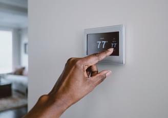 picture of someone adjusting a smart thermostat