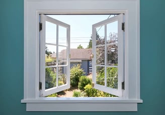 a window with a view of a house and garden