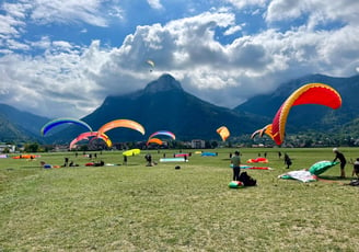 un groupe de personnes s'entraîne à gonfler leur parapente au sol