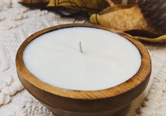 a candle with a candle in a wooden bowl