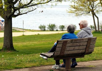 Anziani sereni su una panchina in un parco, simbolo di una pensione tranquilla e pianificata
