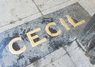 A brass sign in the sidewalk that says "Cecil"