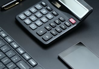 a calculator and a cell phone on a desk