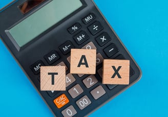 a calculator and a calculator with wooden blocks spelling tax