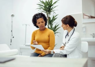 Médica entregando laudo de exame para cliente