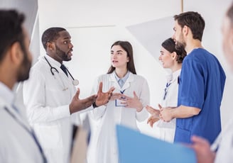 Equipe de médicos e enfermeiros conversando com um paciente