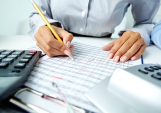 a person is holding a pencil and writing on a paper
