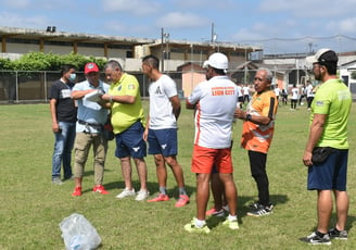 a group of people standing around a soccer field