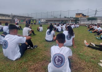 a group of young men and women sitting on a field