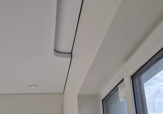 a ceiling with a ceiling fan and a window