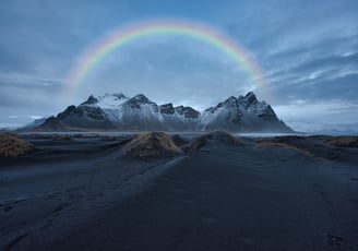 a rainbow - colored rainbow over a mountain range